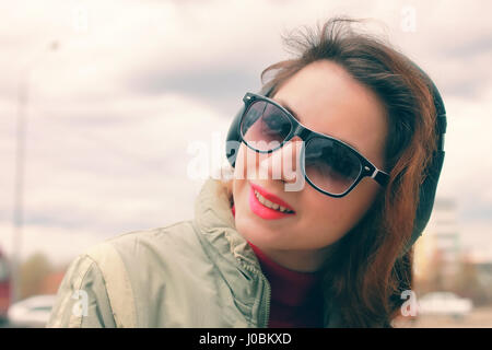 Ragazza nel parco con le cuffie Foto Stock