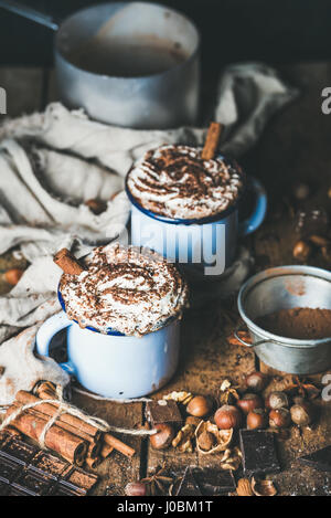 Cioccolata calda con panna montata, bastoncini di cannella e i dadi Foto Stock