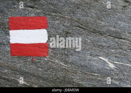 Bandiera austriaca dipinta sulla roccia. trail mark. naturale intero sfondo del telaio Foto Stock