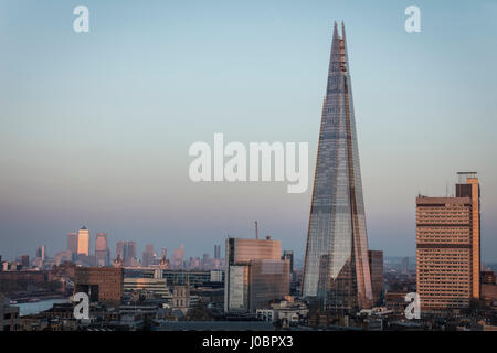 Sunrise luce bassa vista del coccio e Guys Hospital di Londra con Docklands e da Canary Wharf in distanza inondata di sole Foto Stock