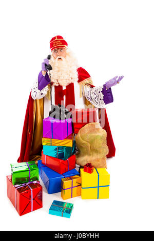 Sinterklaas con presenta e vecchio telefono vintage. isolato su sfondo bianco. Carattere olandese di Babbo Natale Foto Stock