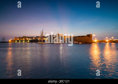 Le luci del tramonto il porto e il centro medievale della città vecchia di Gallipoli, provincia di Lecce, Puglia, Italia Foto Stock