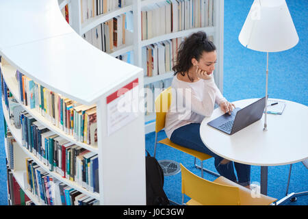 Uno studente universitario che lavorano in biblioteca Foto Stock