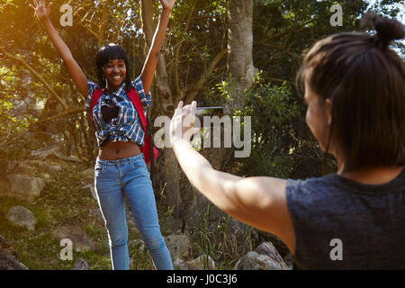 Due amici escursionismo, giovane donna prendendo fotografia di amico, utilizza lo smartphone, Cape Town, Sud Africa Foto Stock