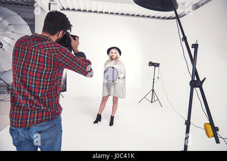 Maschio fotografare Fotografo modello femminile studio su sfondo bianco Foto Stock