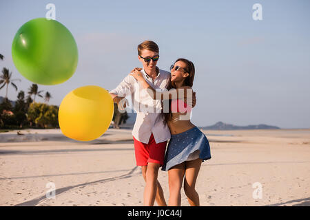 Coppia giovane sulla spiaggia a giocare con palloncini, Koh Samui, Thailandia Foto Stock