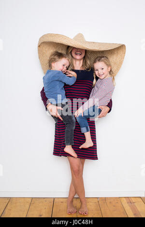 Donna che indossa sombrero, schermatura sia se stessa e due bambini Foto Stock