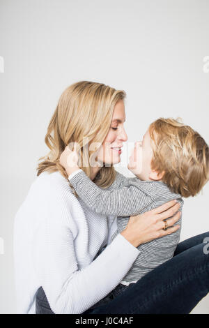 Ritratto di madre e figlio contro uno sfondo bianco, faccia a faccia sorridente Foto Stock