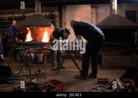 Maniscalchi a ferro di cavallo di forgiatura sull'incudine Foto Stock