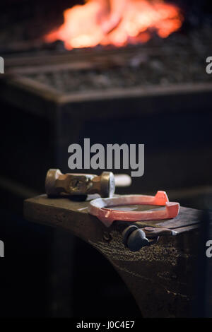Red Hot il ferro di cavallo sull'incudine Foto Stock