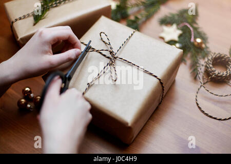 Donna di prua di legatura sul regalo di Natale con la stringa, close-up Foto Stock