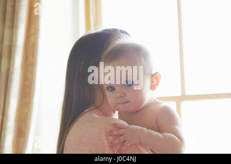 Ritratto di bambina essendo portati dalla madre in camera da letto Foto Stock