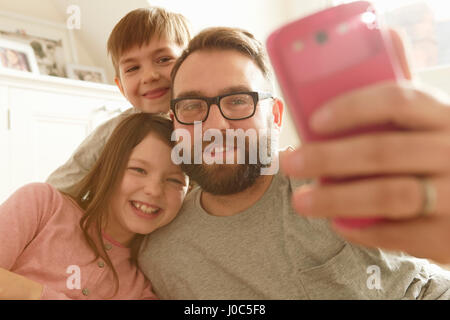 Metà uomo adulto e due bambini prendendo selfie dello smartphone Foto Stock