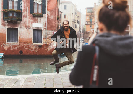 Donna Uomo fotografare il salto da Canal, Venezia, Italia Foto Stock