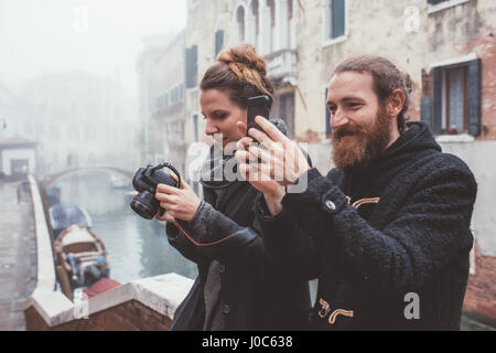 Paio di fotografare sul canal misty waterfront, Venezia, Italia Foto Stock