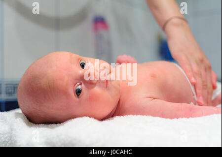 La mamma mette un pannolino sul baby Foto Stock