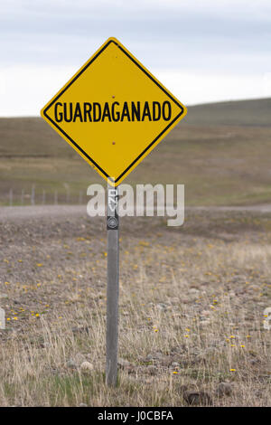 Guardaganado segno di avvertimento di un cattleguard per controllare il movimento di animali tra pascoli su strada rurale Foto Stock