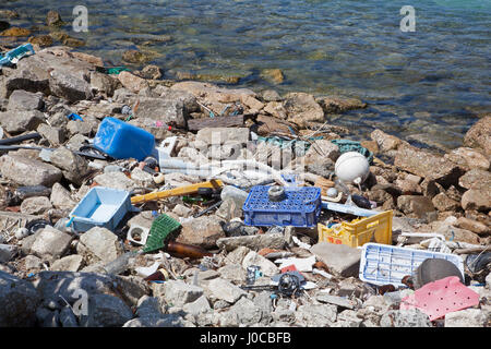 Rifiuti di plastica e detriti marini di vetro lavati a terra nel porto di un'isola del Pacifico settentrionale Foto Stock