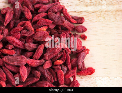 Close up macro shot di goji bacche su una tavola di pino, spazio copia a destra Foto Stock