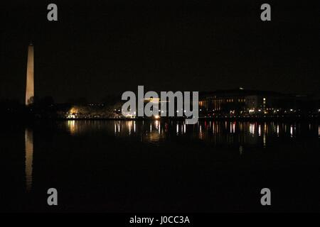 Una bella immagine notturna del Monumento di Washington nella parte anteriore di un corpo di acqua riflettente, con molte luci notturne. Foto Stock