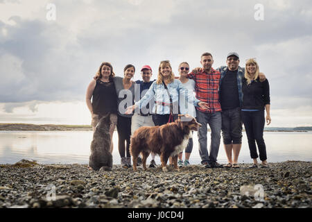 Ritratto di famiglia per adulti e cani sulla spiaggia di ciottoli, Maine, Stati Uniti d'America Foto Stock