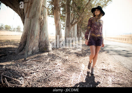 Giovane donna in stile Boho e cappello in feltro per passeggiare sulla banchina Foto Stock