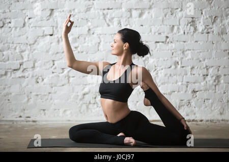 Yogi giovane donna attraente per fare uno zampe piccione re pongono Foto Stock