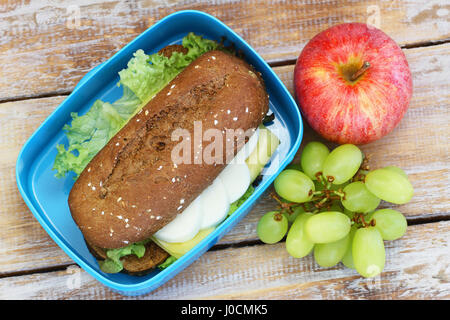 Pranzo sano scatola contenente il rullo di colore marrone con formaggio e uova e frutta fresca Foto Stock