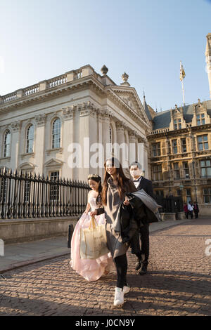 Sposi,asian sposa e lo sposo a piedi al di fuori in strada, Cambridge Regno Unito Foto Stock