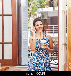 Donna che chiama con lo smartphone in office Foto Stock