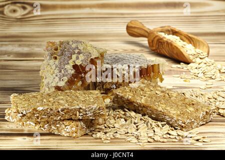 Granola bar con ingredienti su sfondo di legno Foto Stock