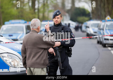 Dortmund, Germania. Xii Apr, 2017. Un residente locale parla di un funzionario di polizia blocca una strada a Dortmund, Germania, il 12 aprile 2017. Tre esplosioni si sono verificati nei pressi del blocco stradale accanto al team bus del Borussia Dortmund soccer team durante la sera precedente (11 Aprile). La Champions League a Dortmund è stata annullata dopo l attentato esplosivo che coinvolge due feriti. Foto: Rolf Vennenbernd/dpa/Alamy Live News Foto Stock