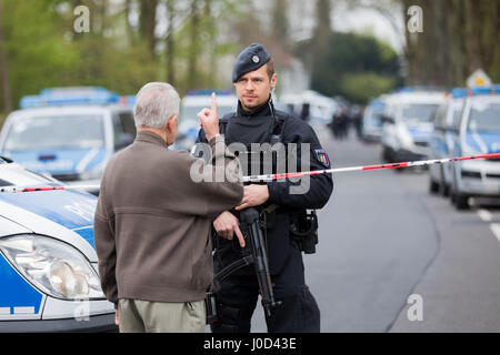 Dortmund, Germania. Xii Apr, 2017. dpatop - un residente locale parla di un funzionario di polizia blocca una strada a Dortmund, Germania, il 12 aprile 2017. Tre esplosioni si sono verificati nei pressi del blocco stradale accanto al team bus del Borussia Dortmund soccer team durante la sera precedente (11 Aprile). La Champions League a Dortmund è stata annullata dopo l attentato esplosivo che coinvolge due feriti. Foto: Rolf Vennenbernd/dpa/Alamy Live News Foto Stock