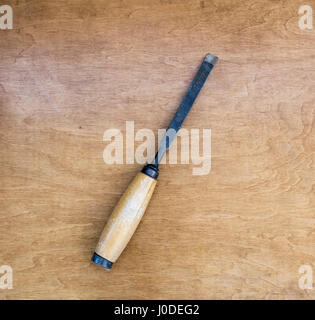 Vecchio scalpello arrugginito isolato su un sfondo di legno Foto Stock