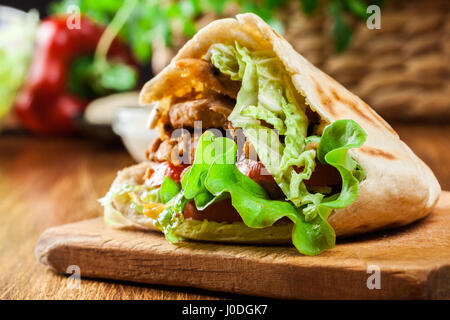 Döner Kebab - il pollo fritto di carne con verdure in pane pita Foto Stock