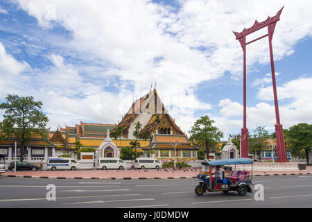 Atuk tuk rigidi passato il gigante Swing con il Wat Suthat in background, Bangkok, Thailandia Foto Stock