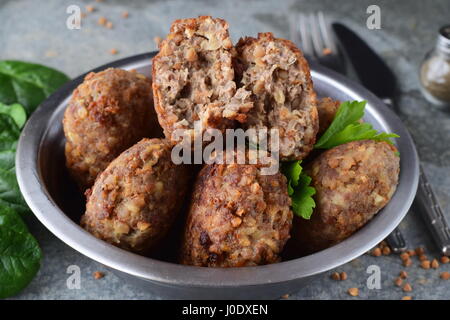 Polpette con grano saraceno in una ciotola di metallo su un grigio Sfondo astratto.il cibo sano.mangiare sano concetto. Foto Stock