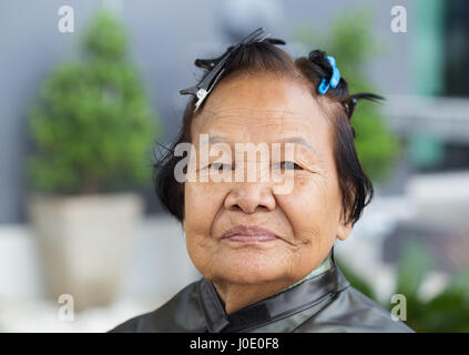 Donna senior con coppiglia su i suoi capelli Foto Stock