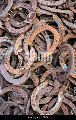 Cumulo di usato e usurato rusty cavalcate al di fuori del fabbro maniscalchi shop o antica fucina Foto Stock