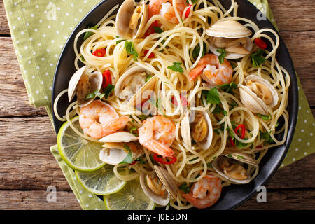 La pasta italiana con le vongole e gamberetti close-up su una piastra orizzontale di vista da sopra Foto Stock