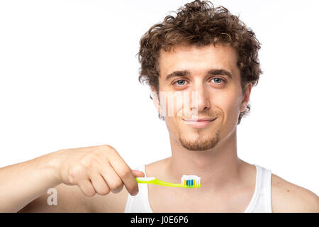 Curly divertente gli uomini con la canottiera bianca spazzolando i suoi denti con cura, isolato su bianco Foto Stock