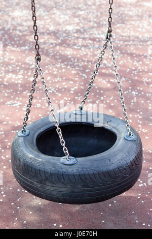 Vista superiore in prossimità dei figli in gomma nera tire swing ruota sospesa su catene metalliche Foto Stock