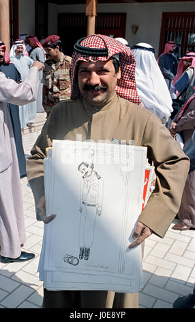 Un artista kuwaitiani sorrisi come egli mostra off anti-Iraq disegni ha in mente di presentare l'emiro del Kuwait Sheikh Jaber al-Ahmad al-Sabah in seguito alla liberazione Marzo 16, 1991 a Kuwait City in Kuwait. Dopo quattro giorni di combattimenti, tutte le truppe irachene furono espulsi dal Kuwait, finendo a quasi sette mesi di occupazione del Kuwait da parte dell'Iraq. Foto Stock