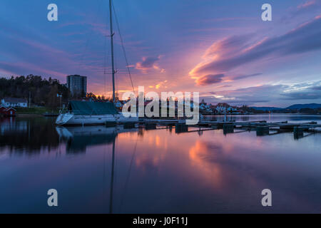 Tramonto sul dock, porto e le barche, riflette le nuvole colorate in acqua di fiume - Porsgrunn, Norvegia Foto Stock