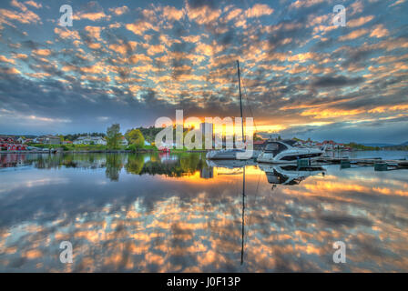 Incredibile, colorato, meraviglioso tramonto del CIT e il fiume in Porsgrunn, Norvegia. Le nubi sono lavati in colori e il cielo si riflette nell'acqua Foto Stock