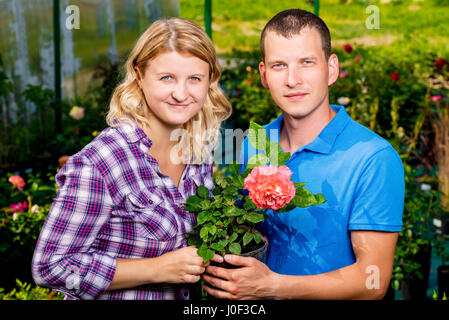 Coppia felice con una rosa in un ritratto di vivaio Foto Stock