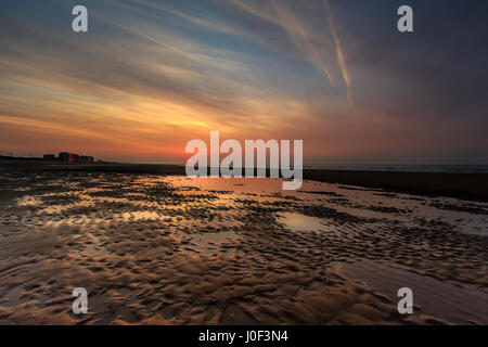 Drammatico tramonto colorato. La bassa marea rivela alcuni stagni e ribbles nella sabbia fatta dal mare. Spiaggia di Ostenda, Belgio Foto Stock