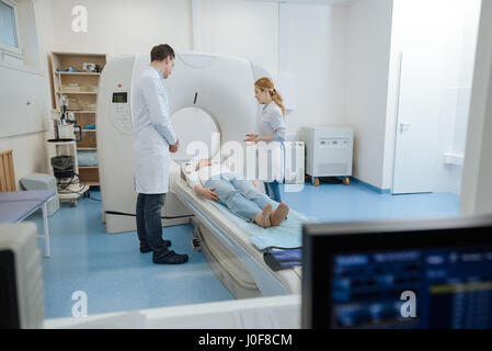 Bellissima femmina medico che allietava il suo paziente Foto Stock