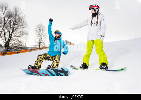 Coppia giovane di Snowboard divertirsi sulla neve-coperta hill Foto Stock
