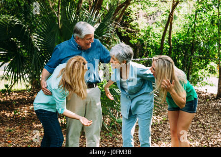 Coppia senior e due figlie adulte in parco divertimento Foto Stock